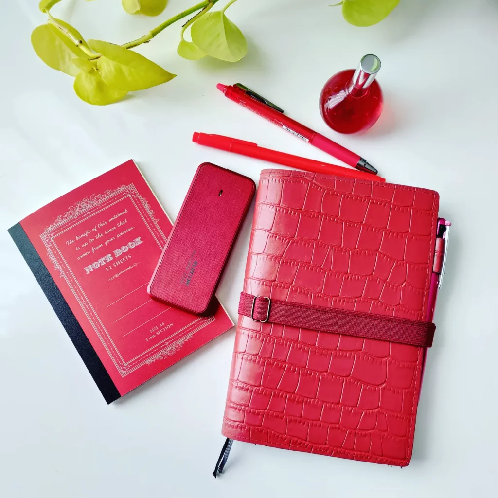 赤い色の文房具の写真、手帳、外付けメモリ、メモ帳、ペン