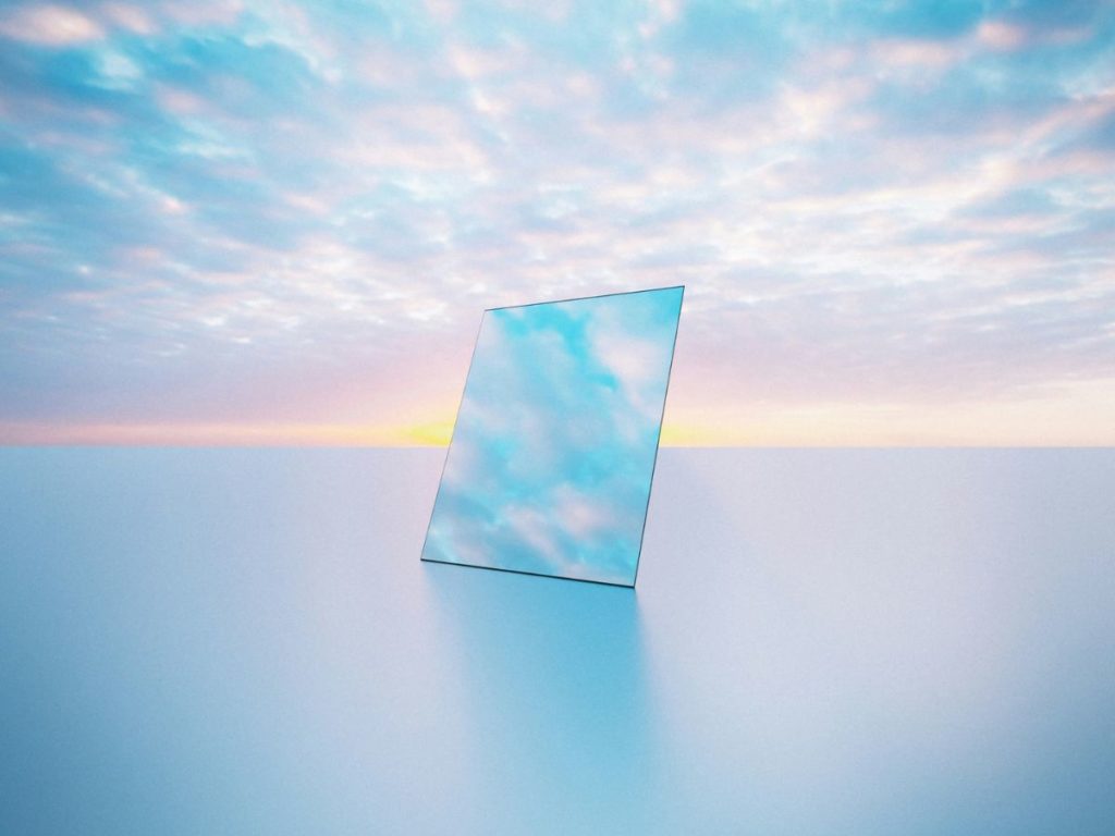 雲が流れている好きとおるような空と静かな水面の上に鏡が置かれている幻想的な空間の画像