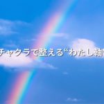 白い雲が浮いている空に、7色の虹がかかっている画像
